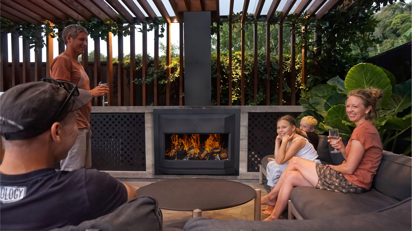 People sitting around an inbuilt Pique Ascent outdoor fireplace in a garden setting